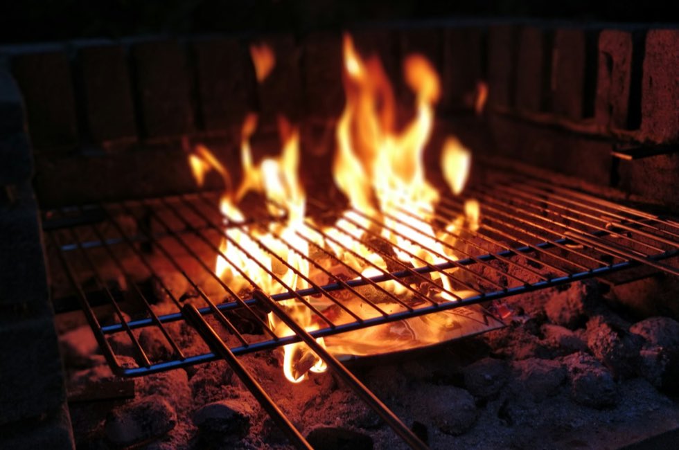 Brasas encendidas bajo una parrilla