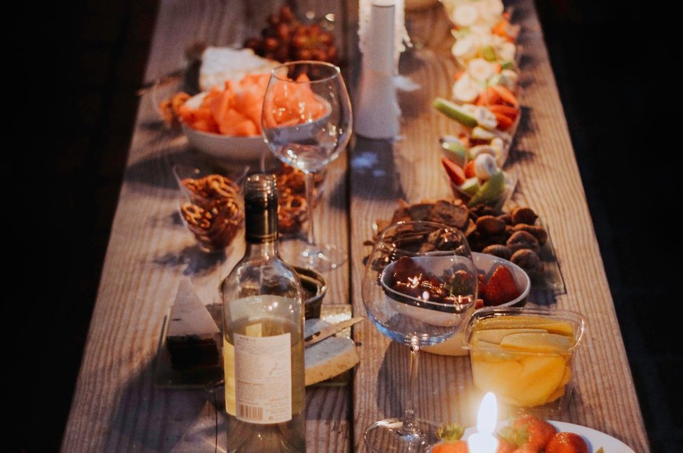Mesa larga de madera servida con platos y bebidas