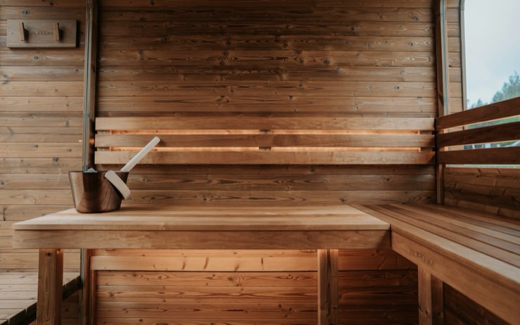 Interior del sauna de madera con balde y cucharón
