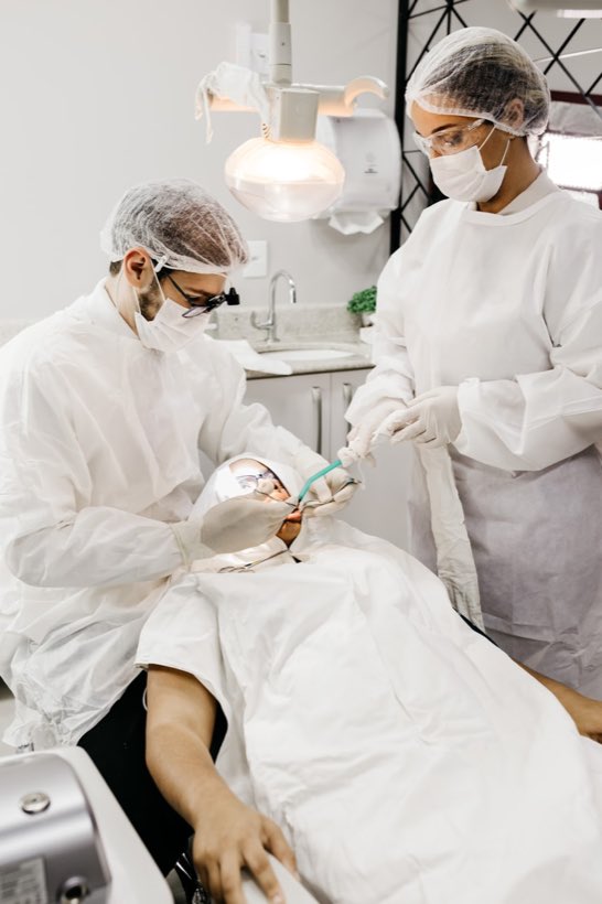 Profesional de la salud con ambo blanco preparando el instrumental