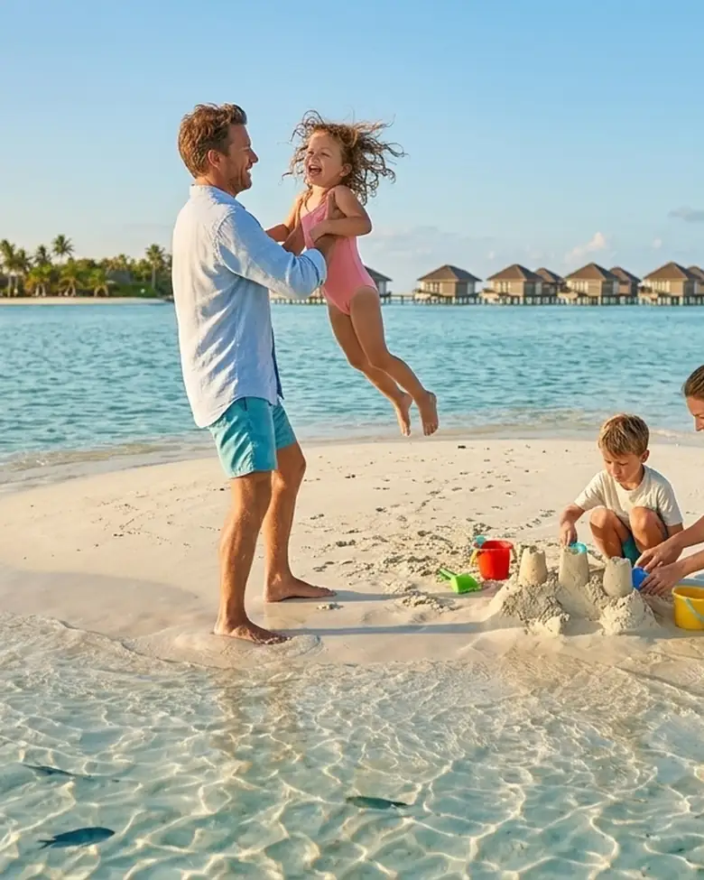 Familia jugando con la arena en un banco de arena, con villas sobre el agua al fondo